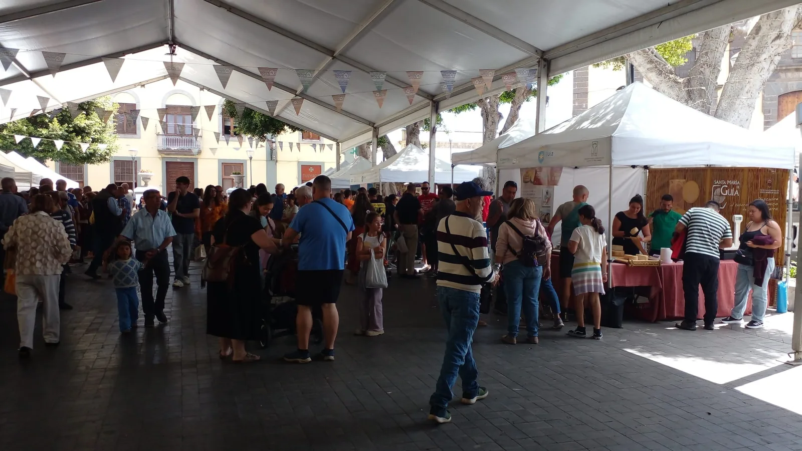 Plaza Grande in Santa María de Guía während der Fiesta del Queso 2026, Familien zwischen Käseständen unter Wimpeln