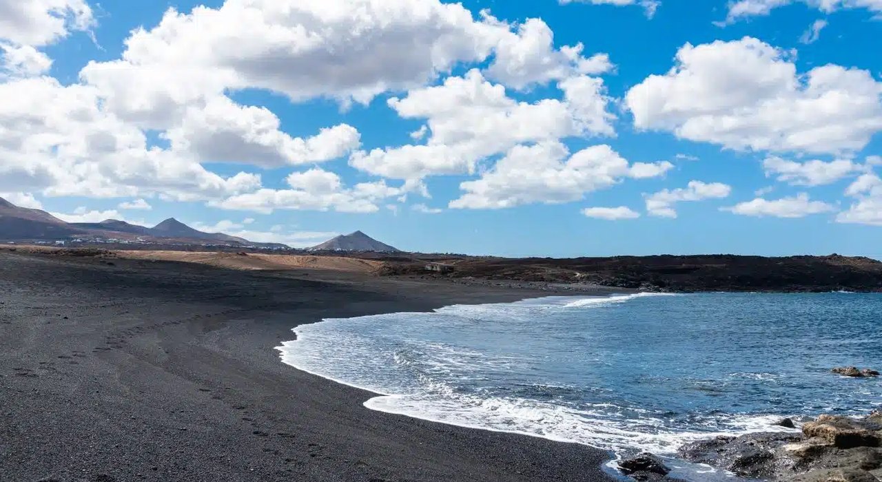 Playa del Janubio en Lanzarote — playa de arena negra volcánica con paisaje montañoso