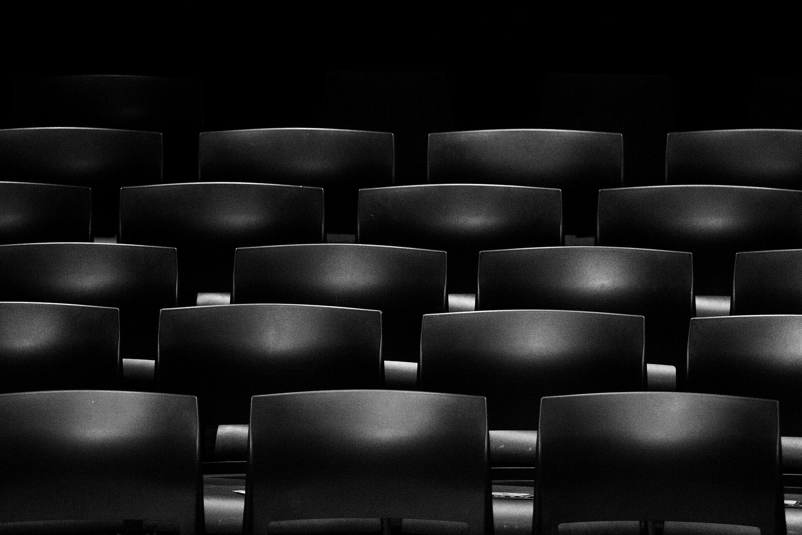 Interno di una sala cinematografica moderna con poltrone reclinabili in pelle rossa