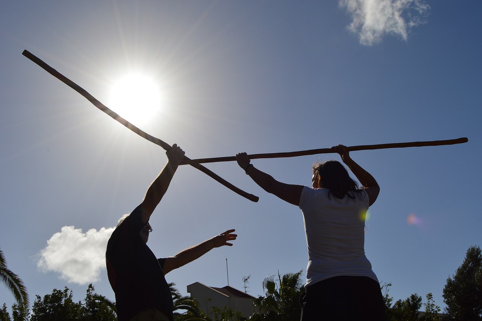Dos jugadores practicando el juego del palo canario al atardecer