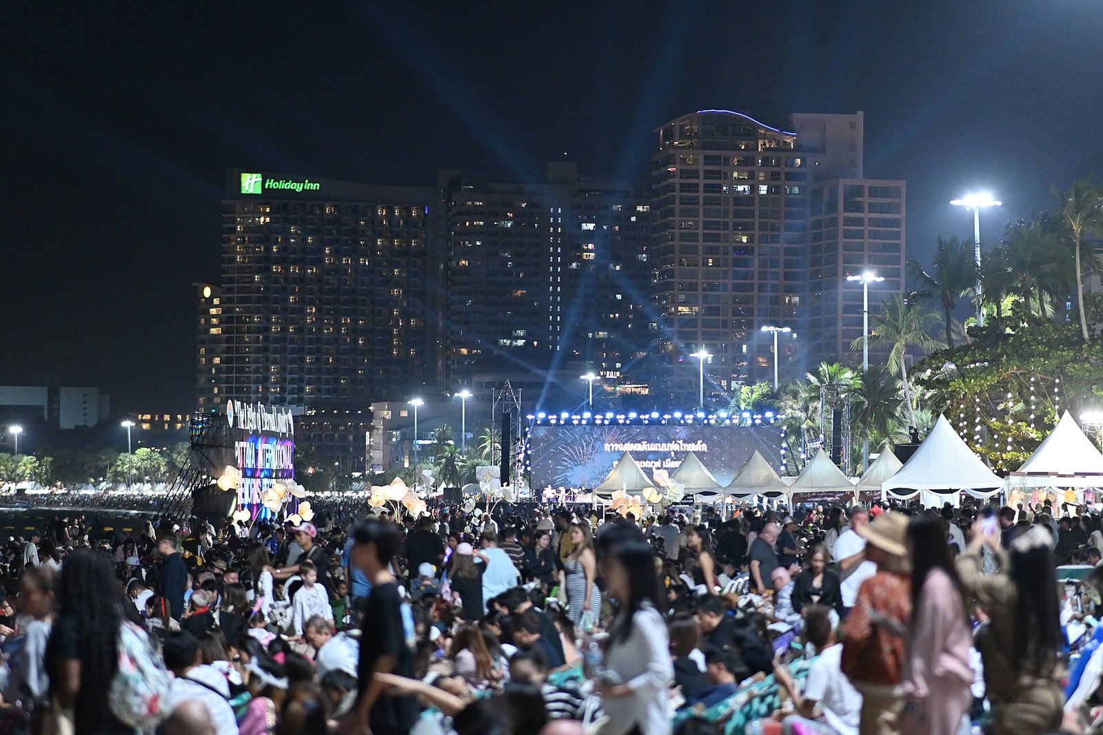 Crowd enjoying an urban music festival at sunset with stage lights