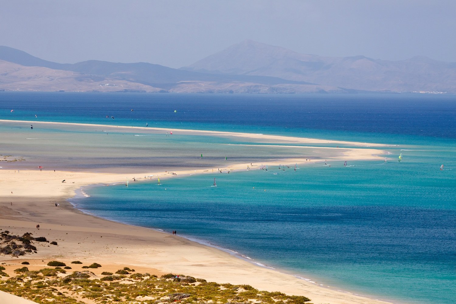Windsurfer springt über das türkisfarbene Wasser der Playa de Sotavento