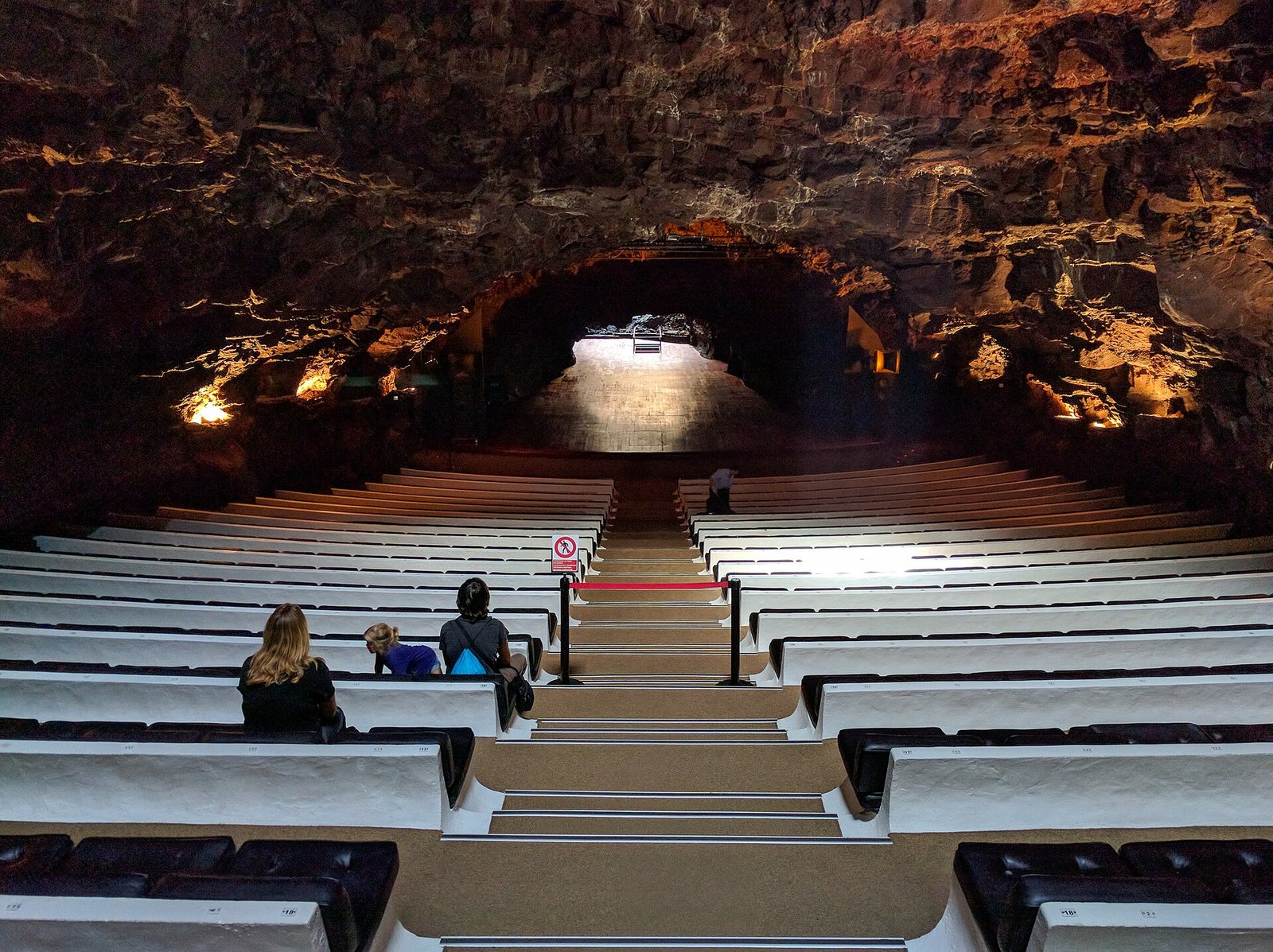 Interno dell'auditorium naturale dei Jameos del Agua con sedute in pietra e pareti di lava