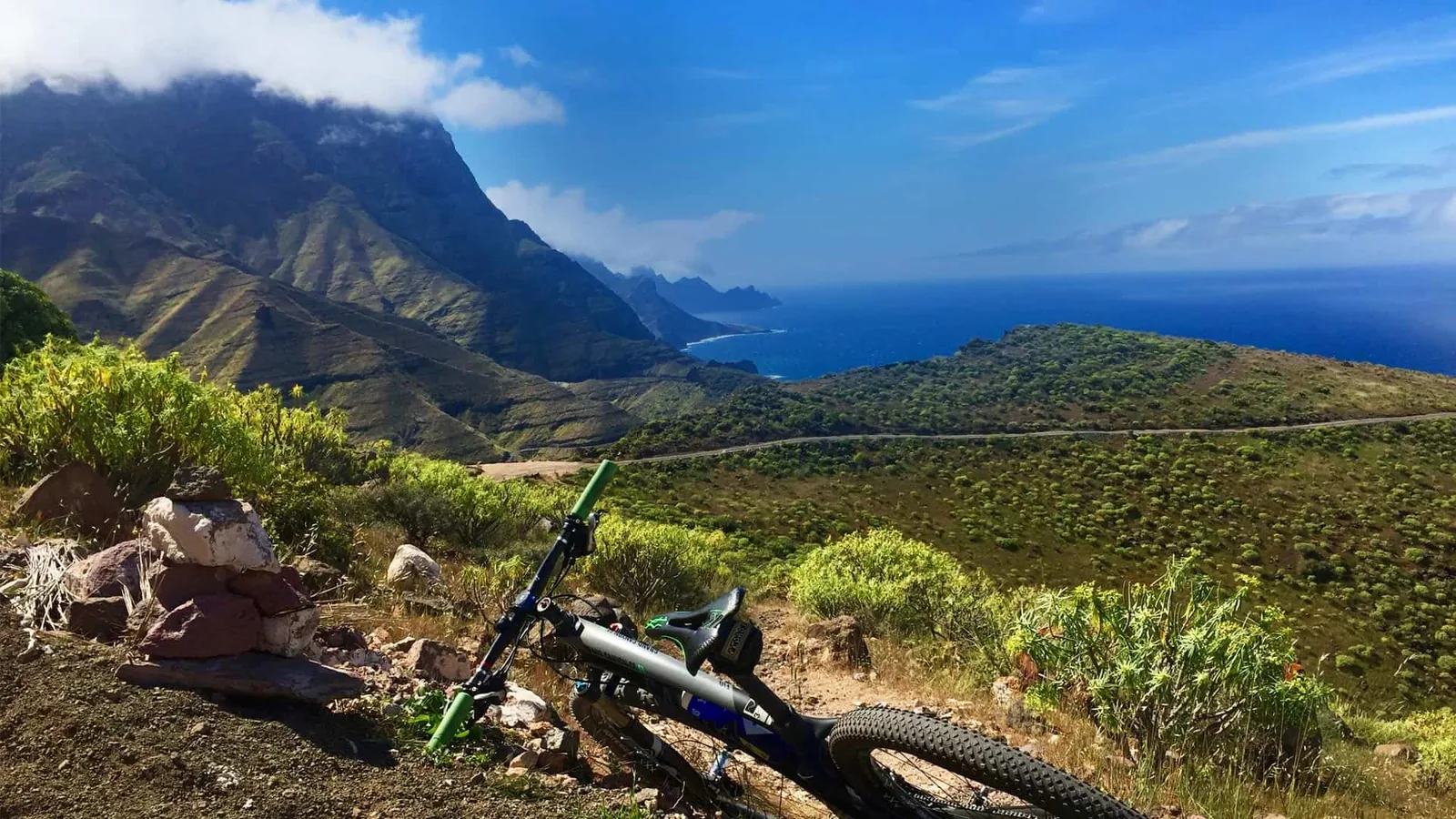 Mountainbike an einer Küstenstrasse auf den Kanaren mit Bergen und Atlantik im Hintergrund