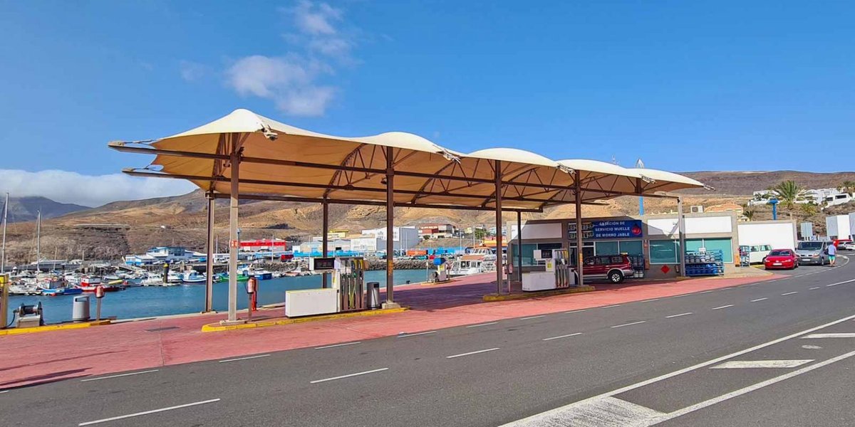 Gasolinera junto al puerto en Canarias con montañas de fondo