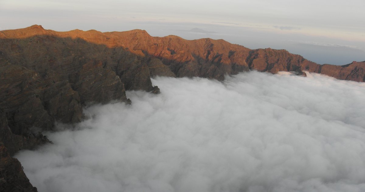 Caldera de Taburiente on La Palma at sunset — sea of clouds and volcanic ridge silhouette, symbol of the island in economic transition 2026