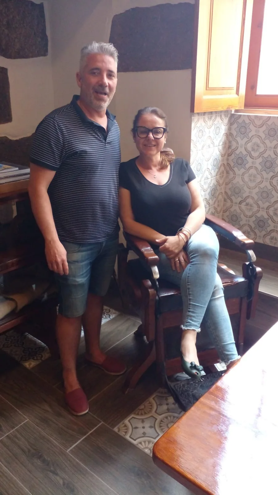 Tamara y Antonio de Guía en su patio junto al sillón de cuero antiguo